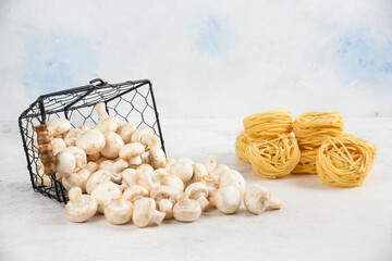 White mushrooms in a metallic basket with noodles