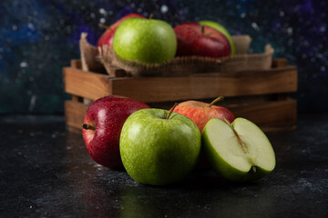 Wooden box of fresh organic apples on black background