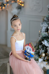 A small ballerina  near the Christmas tree. The Nutcracker . New Year's gifts