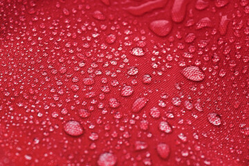 Red waterproof cloth covered with water drops
