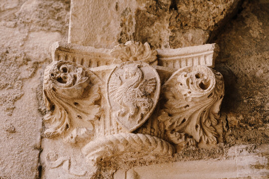 The top of a bas-relief column with a shield pattern depicting a dragon, in the old town of Kotor, Montenegro.