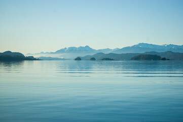 Calma en el lago con las montañas de fondo y la bruma del atardecer. Bariloche, Argentina 