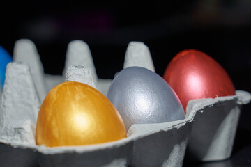 Colored pearly coloured eggs for Easter in the egg tray close up.