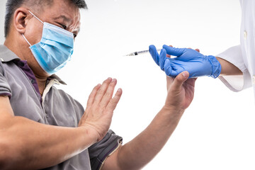 Fearful worried middle age man reacting to medical practitioner holding syringe loaded with...