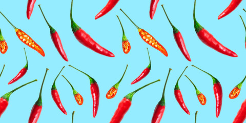 Seamless pattern of red hot chilli peppers isolated on blue background. Top view