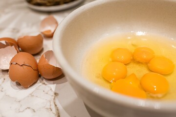 Bowl with 6 egg yolks and shells on the side