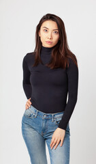 young attractive woman in black sweat-shirt and jeans, casual wear isolated on studio background