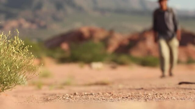 Man walking in the Desert. Low Angle View. Zoom In. 4K Resolution.