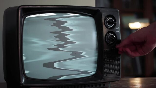 Male Hand Turning On a Vintage Retro TV with Static Noise and Green Screen. Zoom Into the Green Screen. Closeup. 4K Resolution.