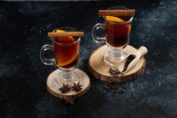 Two glass cups with tasty tea and cinnamon sticks