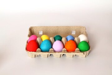 Colorful Easter eggs in egg carton on the table with copy space for text.