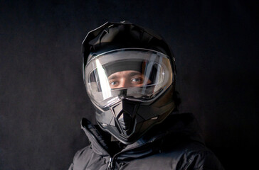 Motorcyclist wearing a black dual-purpose motorcycle helmet with a black jacket.