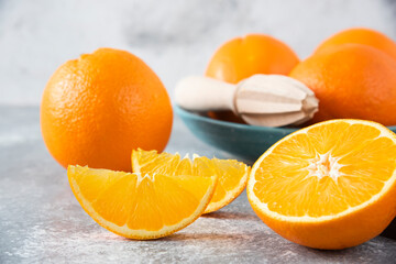 Sliced orange fruits with whole oranges on a wooden board