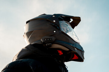 Motorcyclist wearing a black dual-purpose motorcycle helmet with a black jacket.
