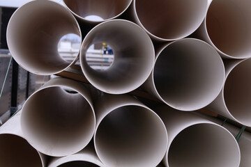 stack of PVC pipes for industrial, manufacturing, engineering, or construction or shop purposes create a cylindrical textured abstract look made with close up tubes