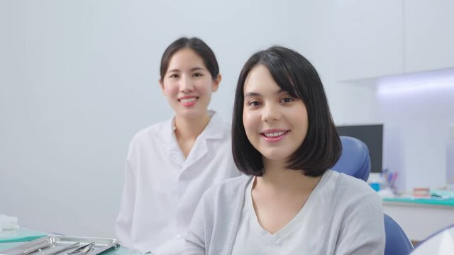 Portrait of Caucasian female patient smiling, and sitting with dentist