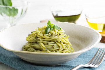 ナチュラルな背景で撮影された、バジルソースのスパゲティー