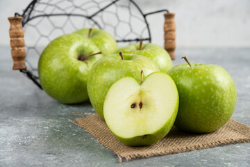 Metal bucket of fresh green apples on marble background
