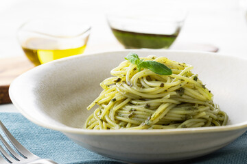 ナチュラルな背景で撮影された、バジルソースのスパゲティー