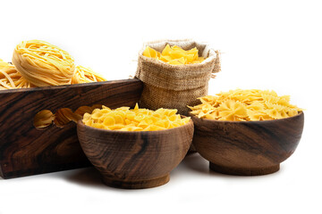 Various types of uncooked pasta in wooden bowls and sack bag