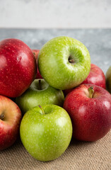 Bunch of fresh green and red apples placed on burlap