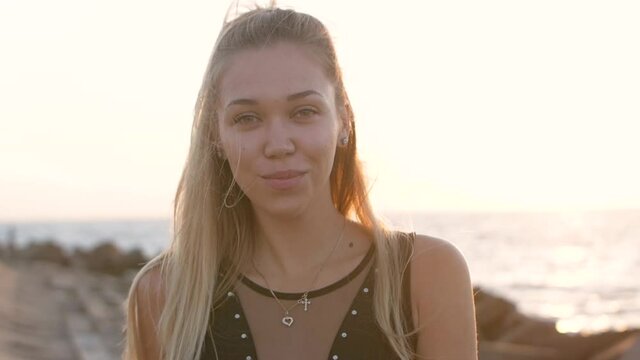 Portrait of attractive blond woman with green eyes smiling at sunset beautiful. Slow motion.