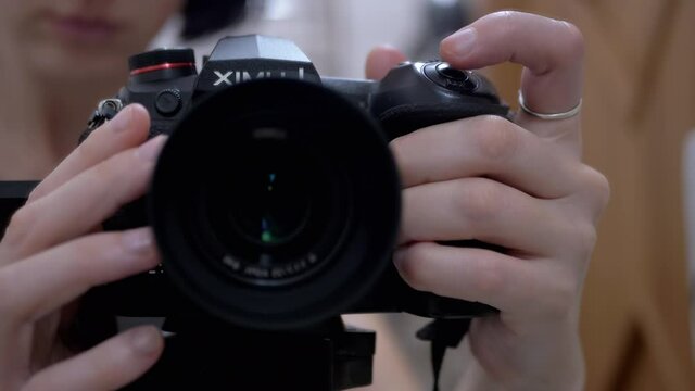 Woman Adjusts Focus Manually on a Modern, New Camera, Camcorder. Camera Lens. 4K