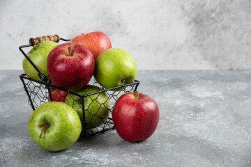 Bunch of fresh green and red apples placed in metal basket