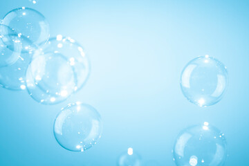 Beautiful shiny transparent soap bubbles floating on a blue background.	