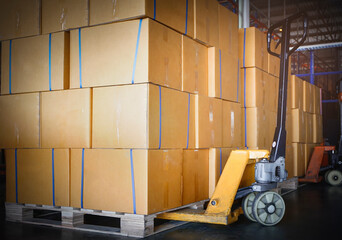 Stack of Card Board Boxes with Hand Pallet Truck. Interior of Storage Warehouse. Cargo Shipment Export- Import. 
