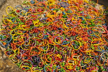 Colored rubber bands were removed from the incense and candles of the monks and left in the temple's cement censer for reuse. Natural resource recycling concept
