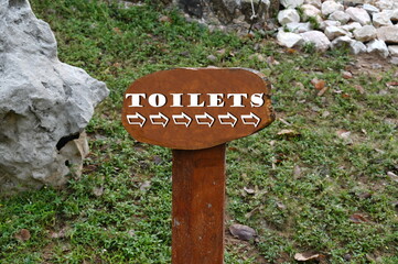 The road signs are made of wood, painted in brown and written in white letters, the word 