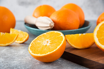 Fototapeta na wymiar Sliced orange fruits with whole oranges on a wooden board