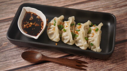 Steamed Gyoza or dumpling stuffed ground pork dipping with garlic soy sauce 