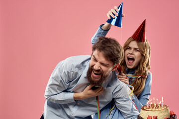 Party man and woman with cake on pink background corporate birthday