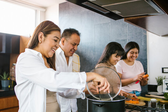 latin family in the kitchen cooking together. Healthy food at home in Latin America