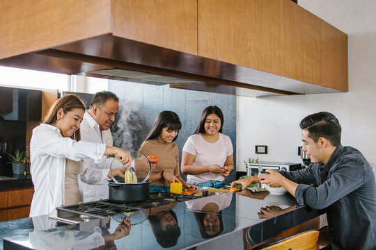 mexican family cooking together in the kitchen. Healthy food at home in Latin America