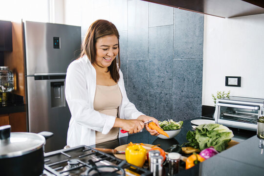latin woman cooking vegetables at home in Mexico city