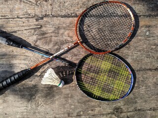 badminton racket and shuttlecock on the wooden table