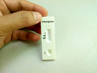 Close view of technician or technologist hand hold a device of chikungunya IgG, IgM rapid screening test, showing positive IgG result