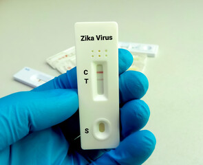 Close view of technician hand hold a device of Zika Virus rapid screening test, showing positive...