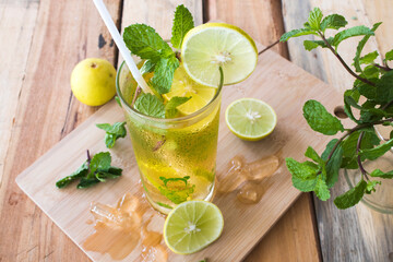 herbal healthy drinks cold  lemon for health care with peppermint leaf and lemon slice arrangement flat lay style on background wooden