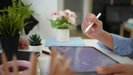 Close up view of man holding stylus pen and digital tablet with blank screen at comfortable...