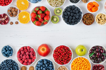 Fresh berries, fruits, nuts on a white wooden background. The concept of healthy eating. Food contains vitamins and trace elements. Copy space.