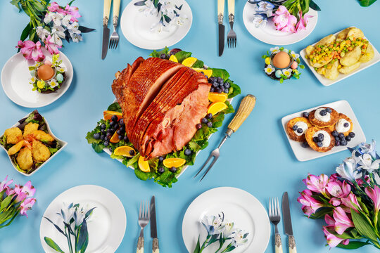 Festive Easter table with ham, salad and pancakes.