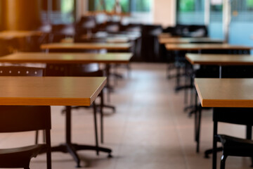 Tables and chairs that is arranged spaced or social distancing in the dining room without people.