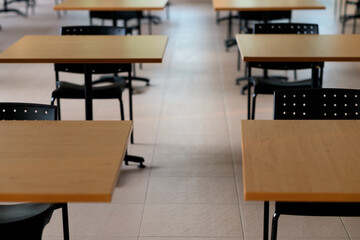 Tables and chairs that is arranged spaced or social distancing in the dining room without people.