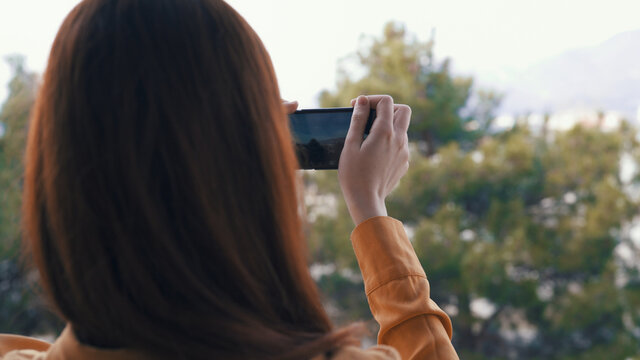 woman with phone in hands taking pictures of nature outdoors panorama