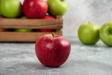 Whole wet green and red apples on wooden cutting board
