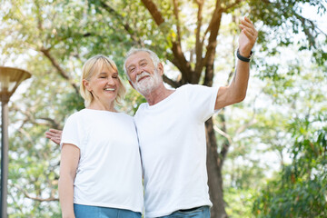 Senior Caucasian couples hugging in park. Family with happy smile feels relaxed with nature in morning. Or evening. Enter elderly society And retire from work. Concept Health care insurance